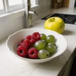An artistic bowl of fresh fruits, enhancing the kitchen ambiance with its colorful display.