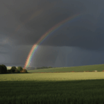 The peaceful countryside is illuminated by the vibrant colors of a rainbow, creating a breathtaking scene of tranquility.