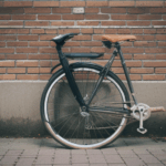 Bicycle resting by a brick wall, a perfect setting for those who appreciate vintage charm.