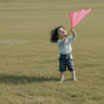 An enchanting moment of a child flying a kite, reminiscent of cherished childhood memories under a bright sky.