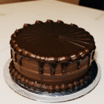 A chocolate cake with thick, luscious frosting, showcasing gourmet dessert artistry.