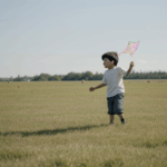 An inspiring scene of a child running with a kite, reflecting the joy and nostalgia of youthful exploration.