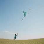 A captivating image of a child flying a kite, emphasizing the freedom and joy experienced in a sunny field.