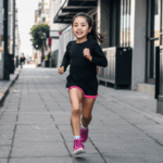 City-loving girl on a spirited run, enjoying the urban landscape and fitness journey.