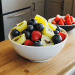 A lively assortment of fresh fruits in a bowl, providing a colorful and healthy kitchen display.