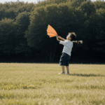 Joyful children engaged in a kite flying adventure in a natural setting.