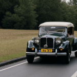 A retro vehicle parked against a breathtaking countryside backdrop, showcasing the timeless beauty of historic automobiles.
