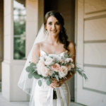 Romantic wedding scene featuring a bride with a floral bouquet.