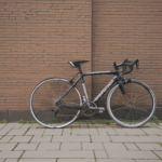 Classic bicycle resting on a brick wall backdrop, evoking nostalgia.